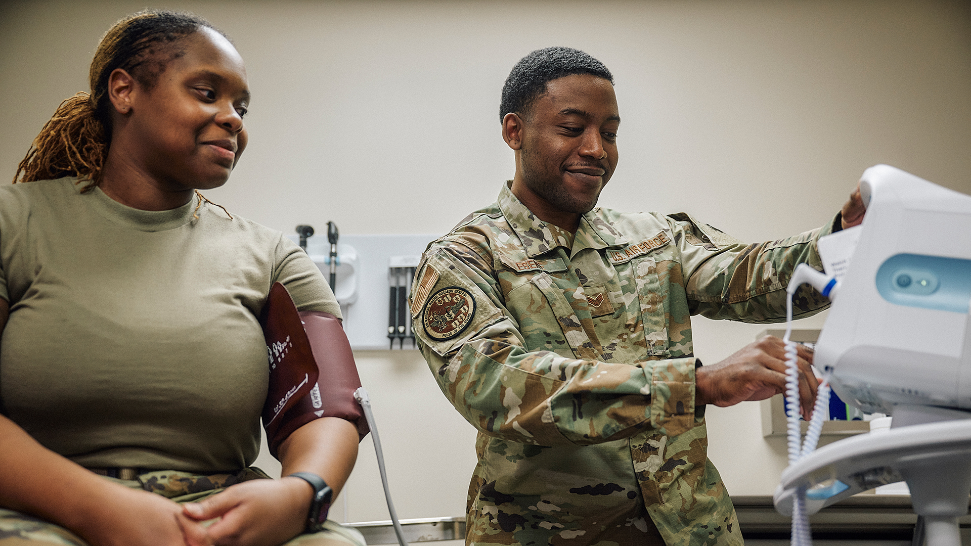 Isaac Esene checking a patients blood pressure 