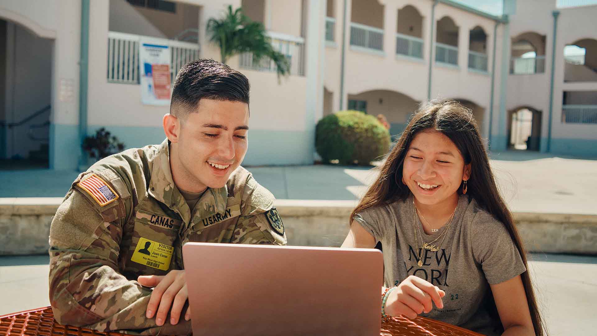 Juan Canas, looking at a computer with a student. 