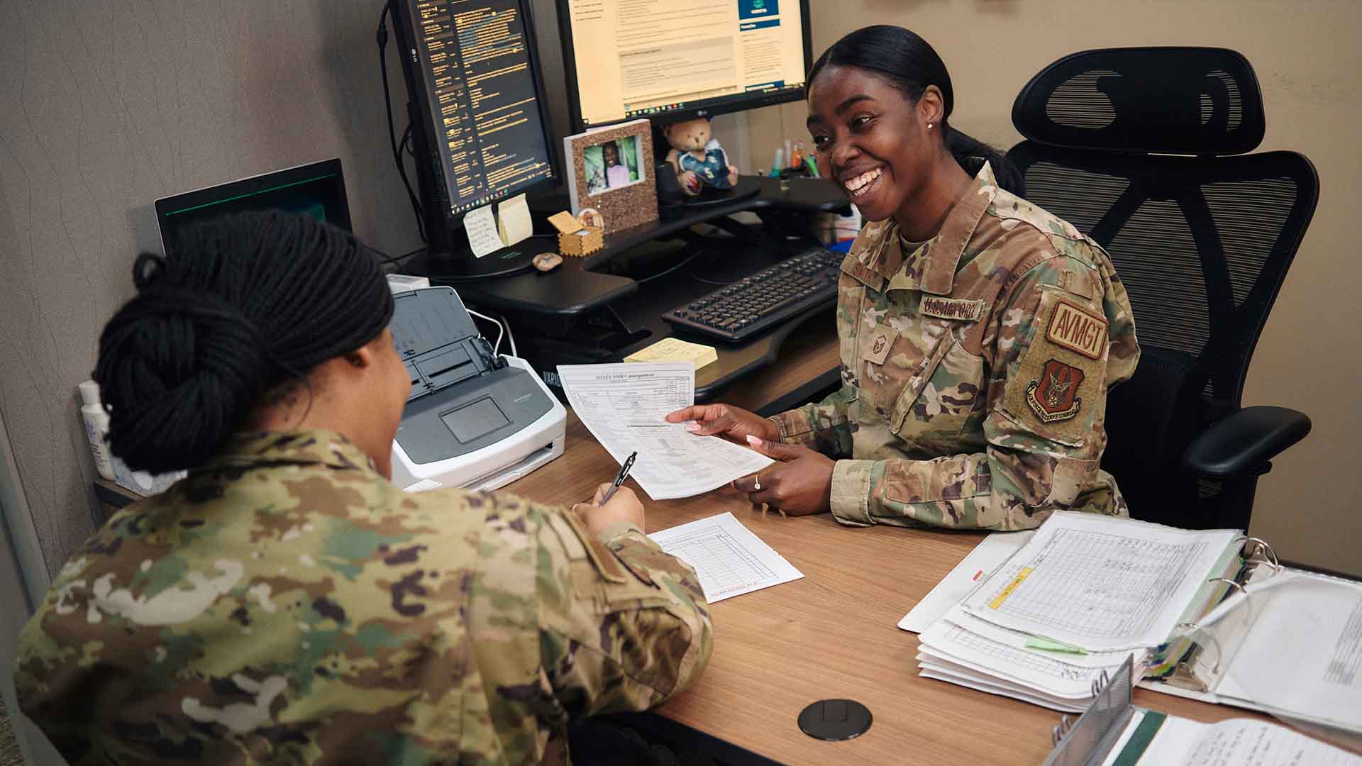 Shakeyna Smith speaking with another service member at her desk.