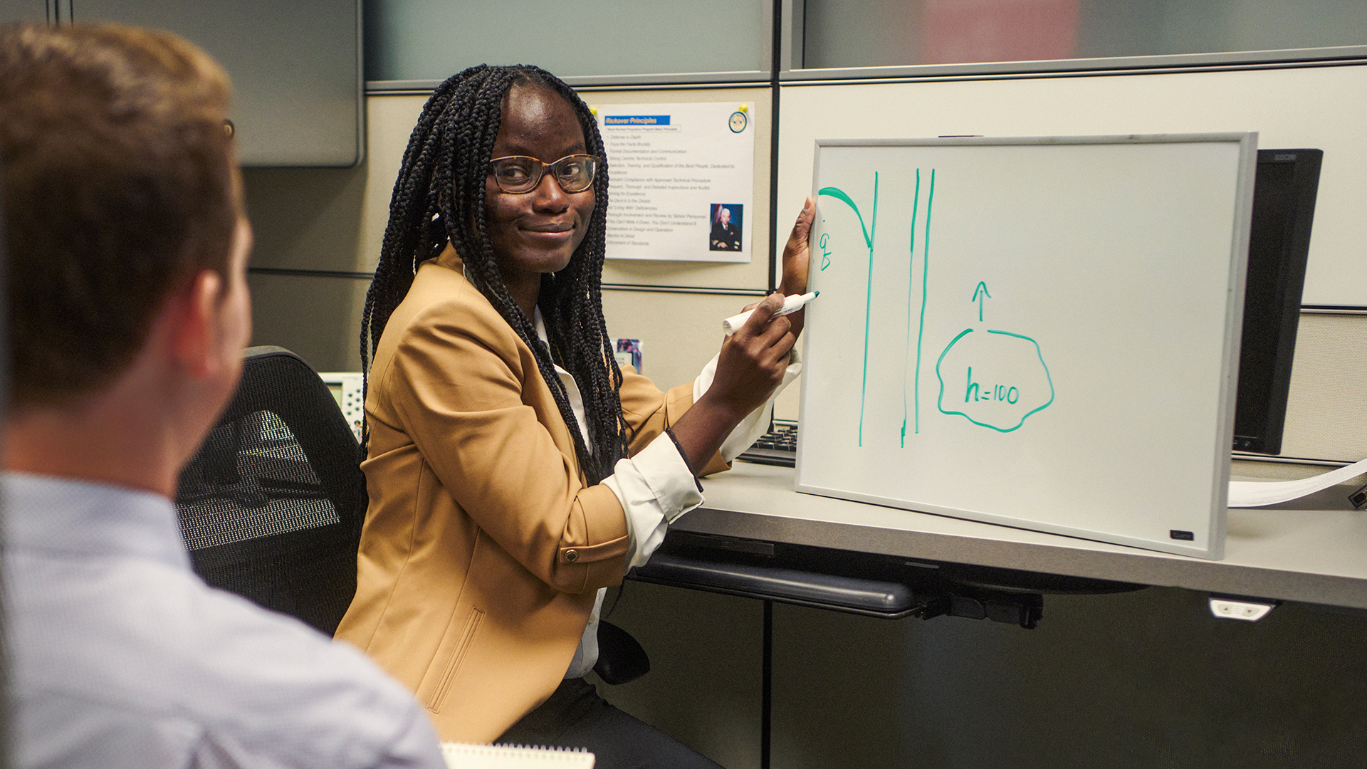 Tyra explaining something using a white board