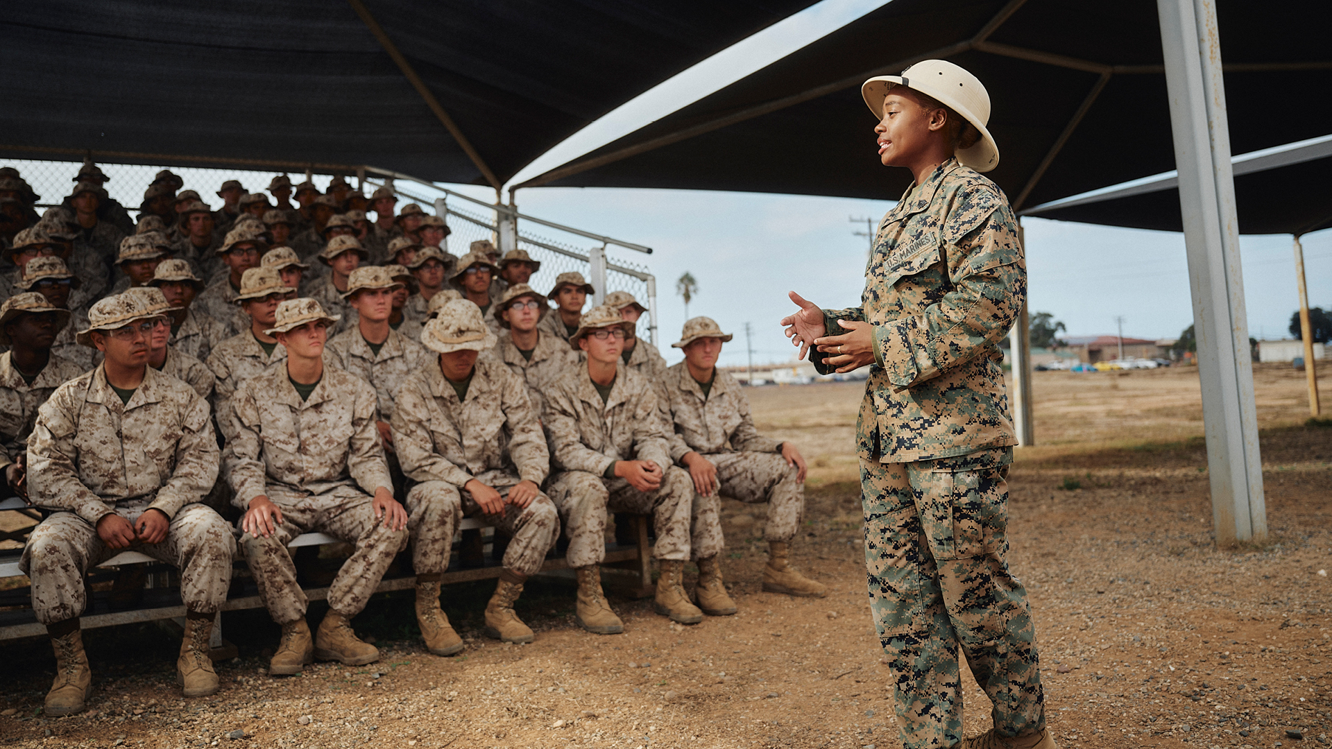 Chyna Gibbs speaking in front of a lot of other soldiers 