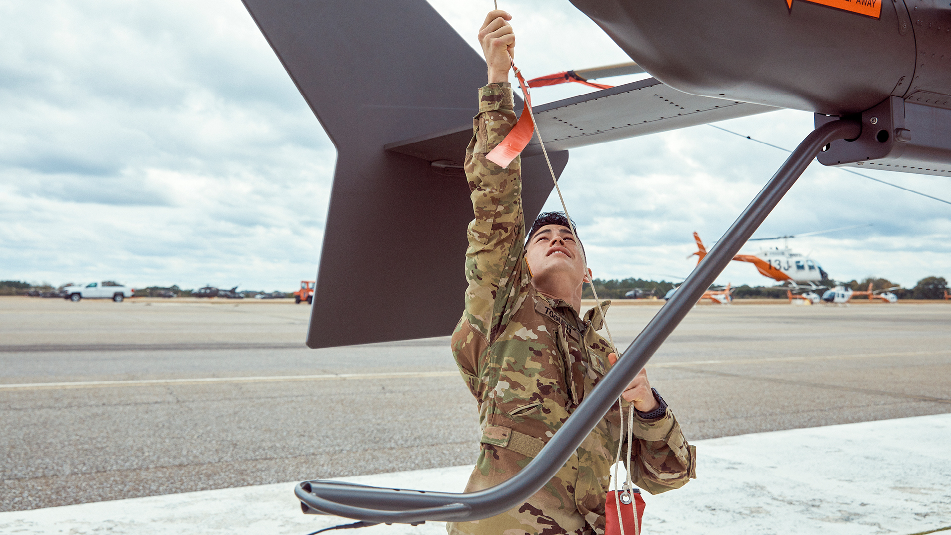 David Toguchi pulling a chain on a helicopter
