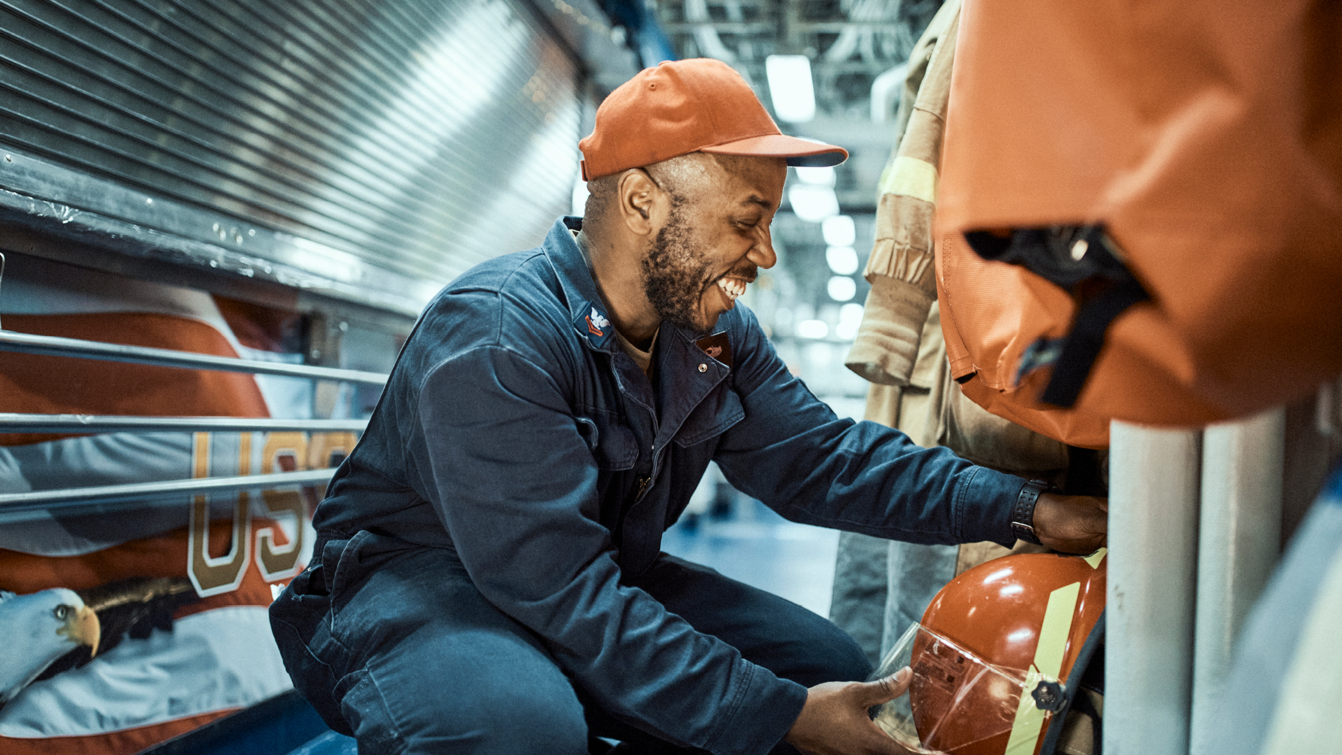 Sidney Wilson bent over smiling while getting his helmet 