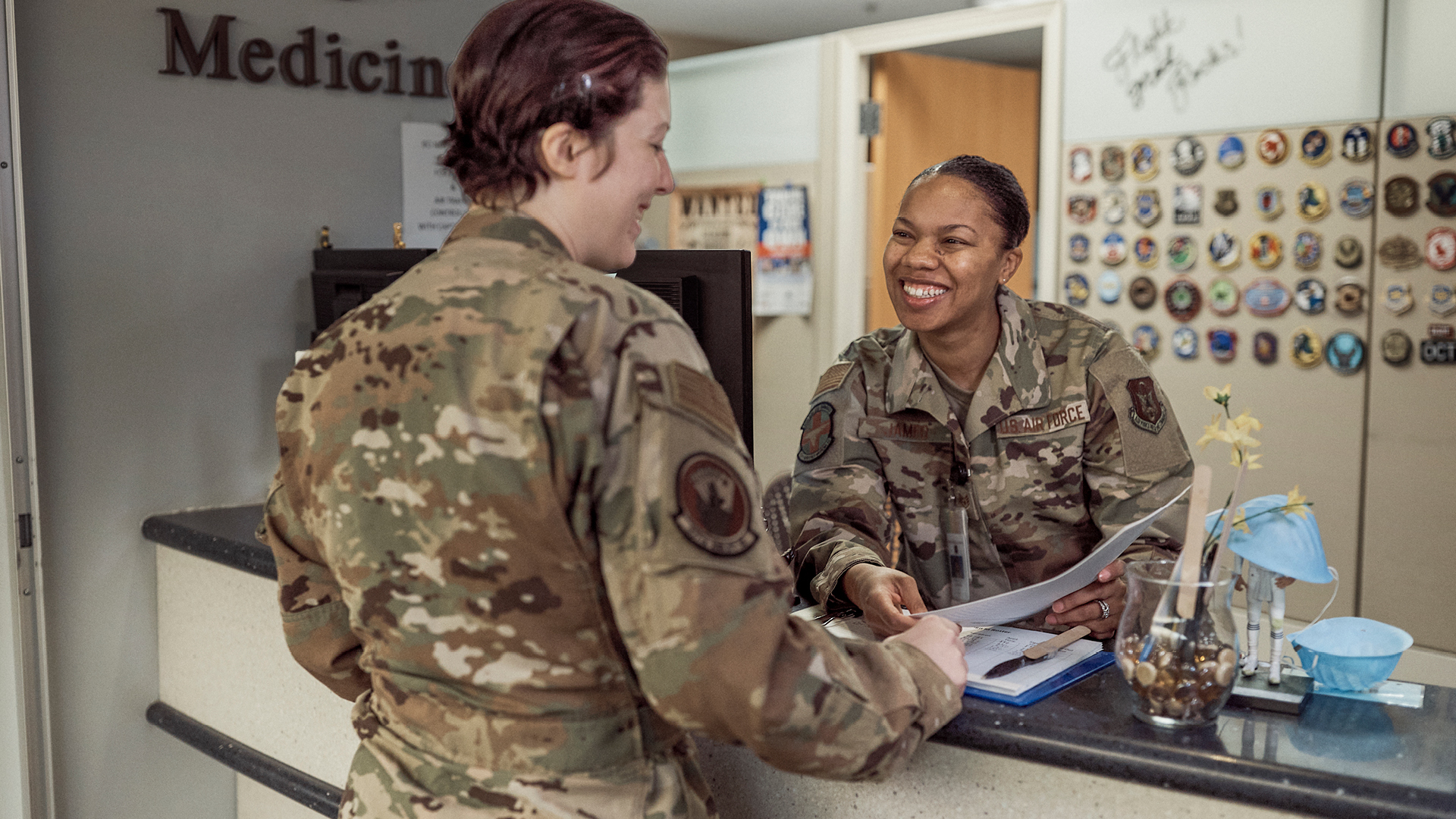 Kaylan James helping a patient at the front desk