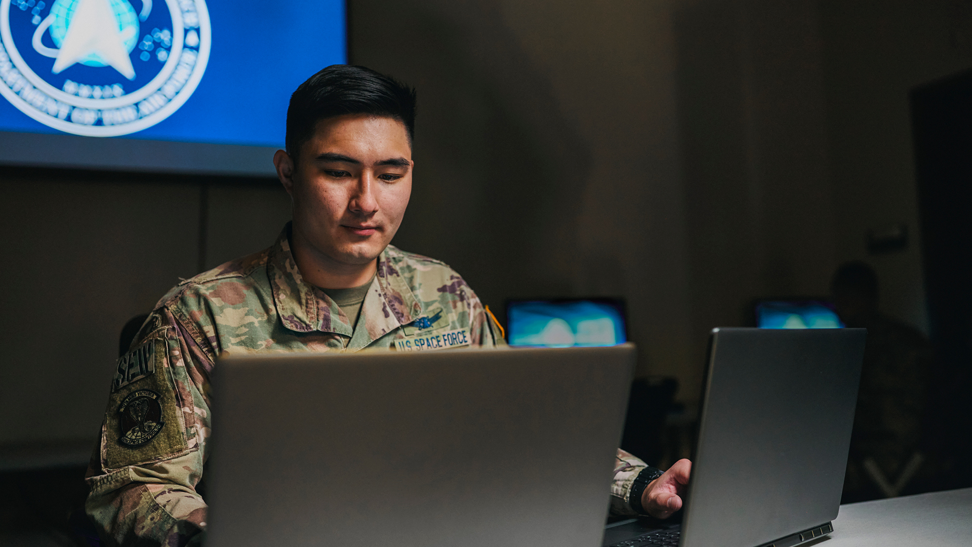 Trenton Ching working at two computers sitting at a desk