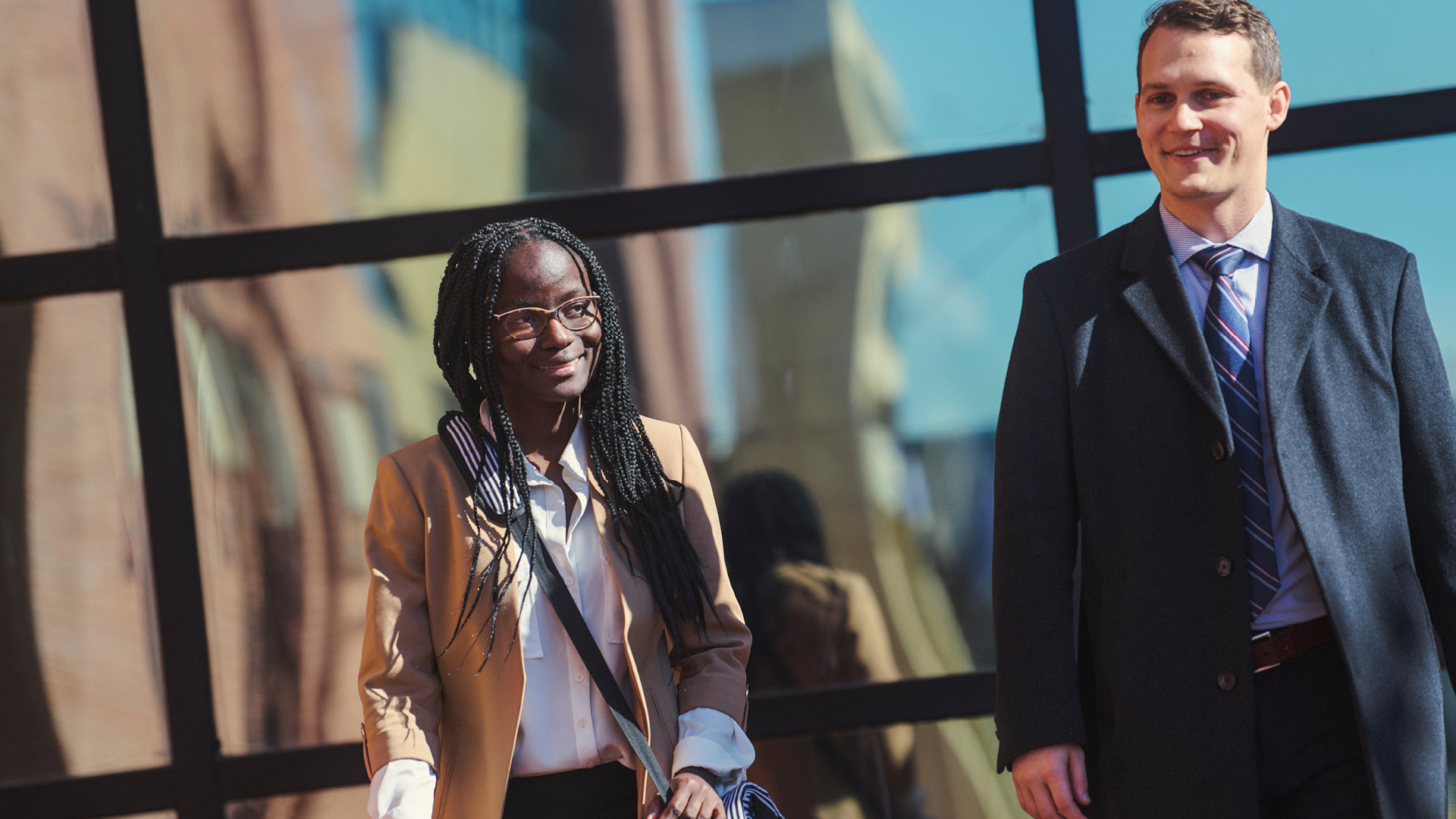 Tyra Newton walking with a coworkers outside of the building they work at.