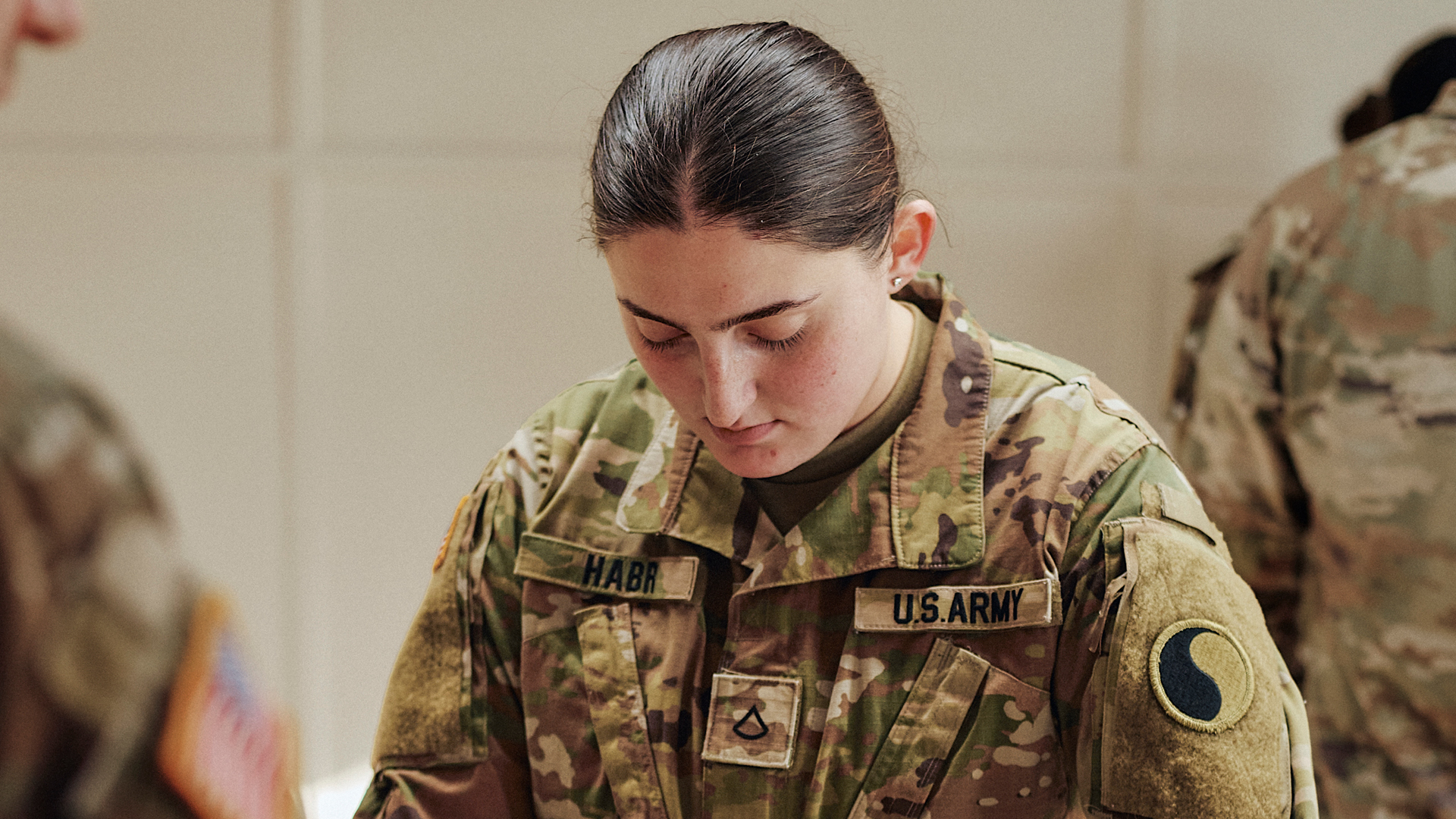 Noor Habr looking down at training material