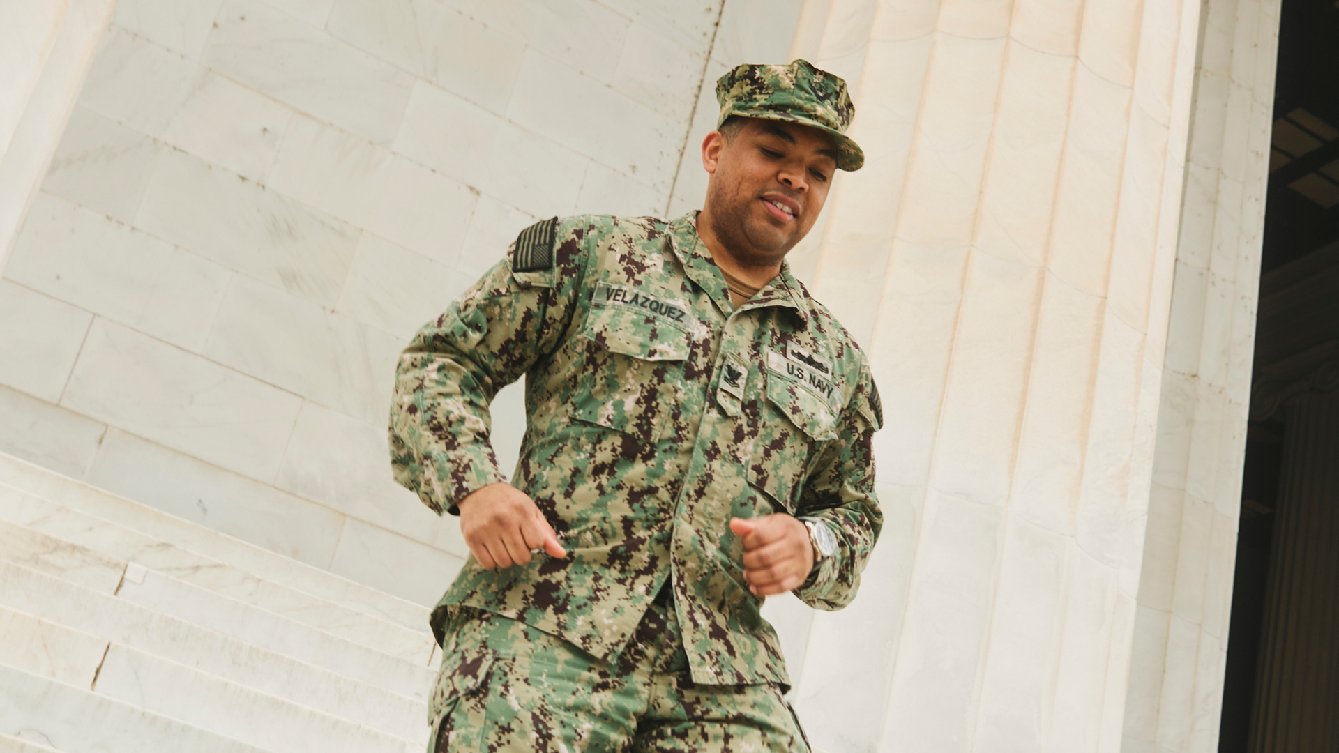 Dominique walking down the steps in full uniform
