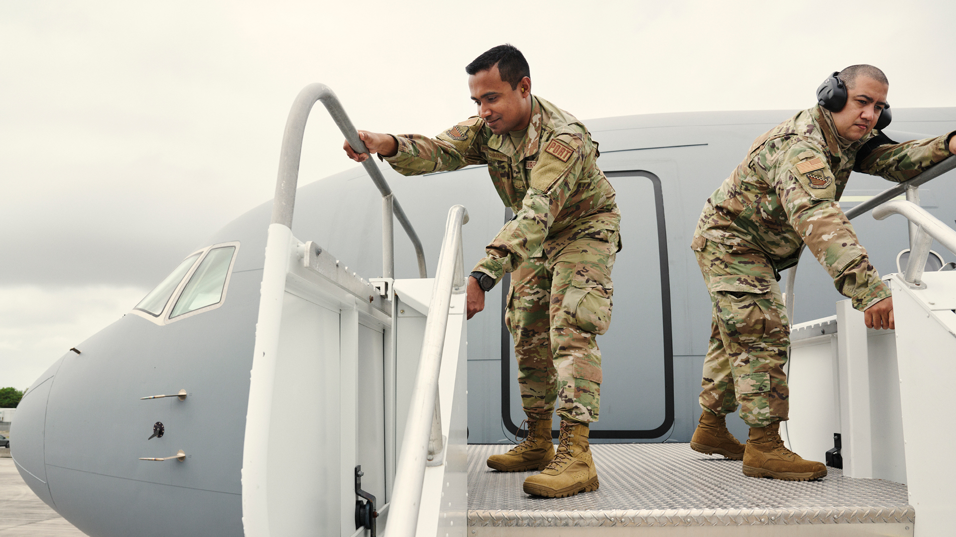 Sourav Choudhury and a coworker closing off the stairs to an airplane