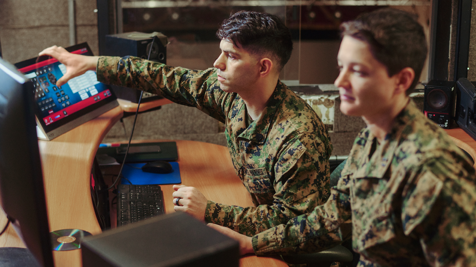Mike pointing at the screen while talking with a coworker