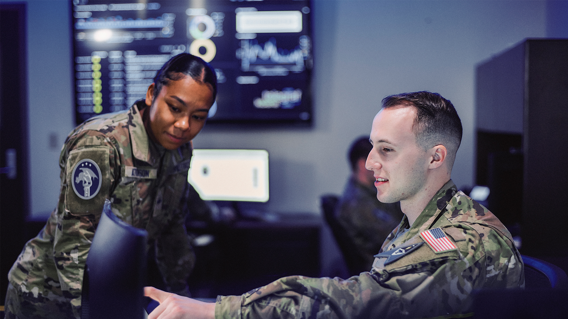 Isaac showing a coworker something on his computer screen