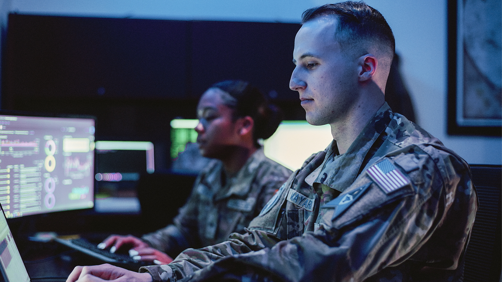Isaac and another coworker sitting at their computers working