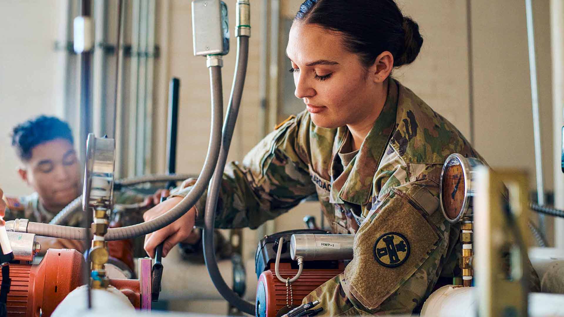 Rebekah fixing pipes with another service member