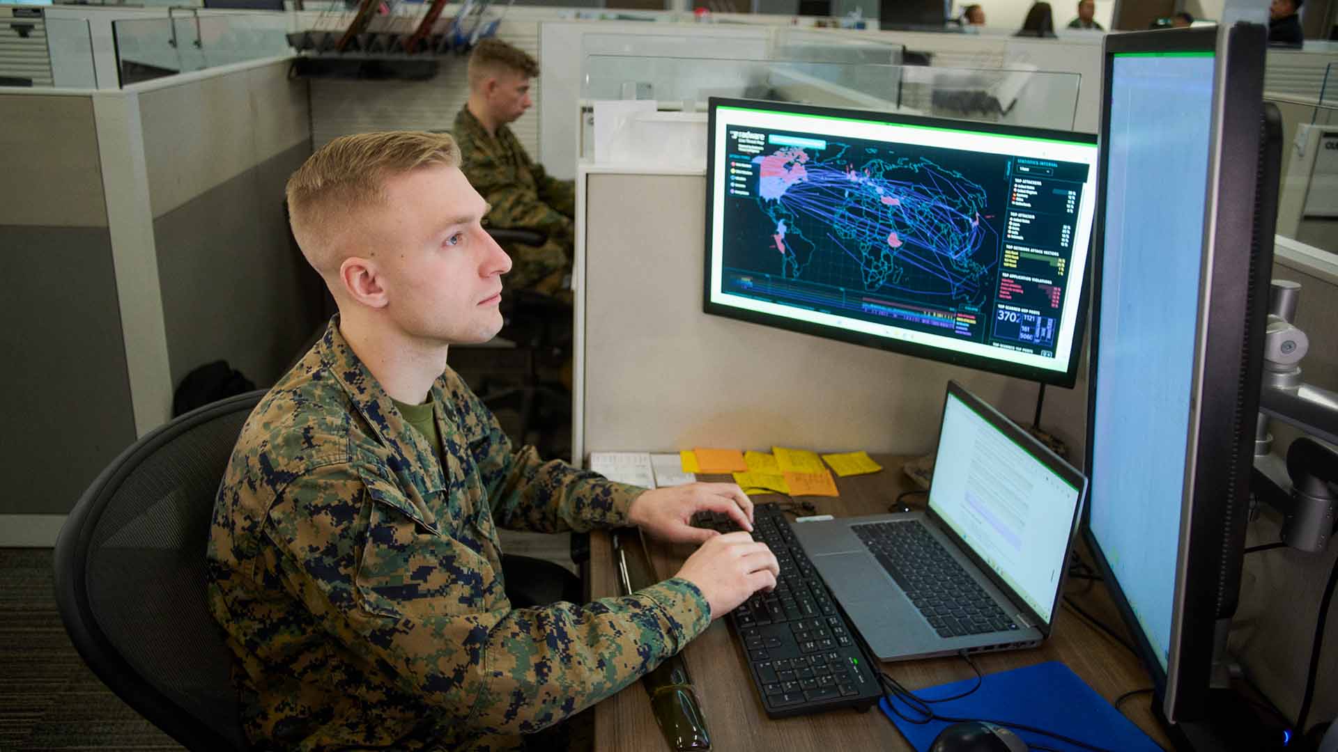 Cpl Rubenbauer on his laptop with a colleague