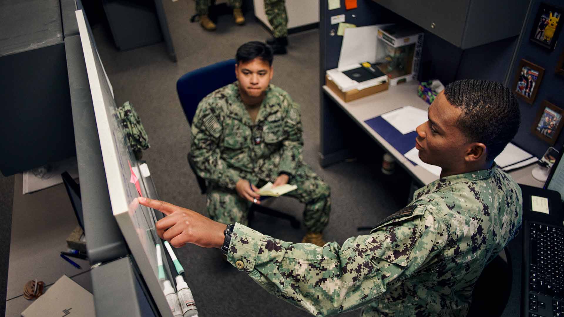 Julian Bedford showing a service member something on a white board