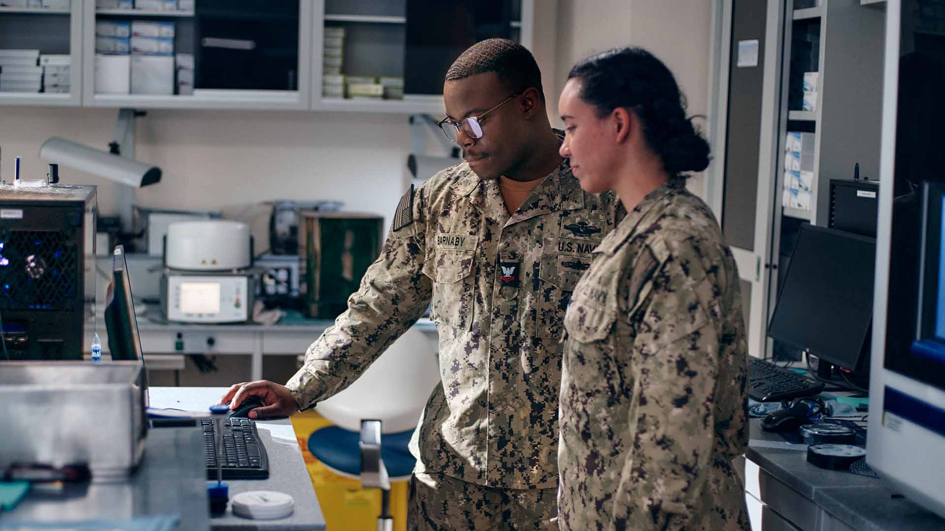 Ofori Barnaby Jr. ("Barnaby") and another service member using a computer in a dental lab