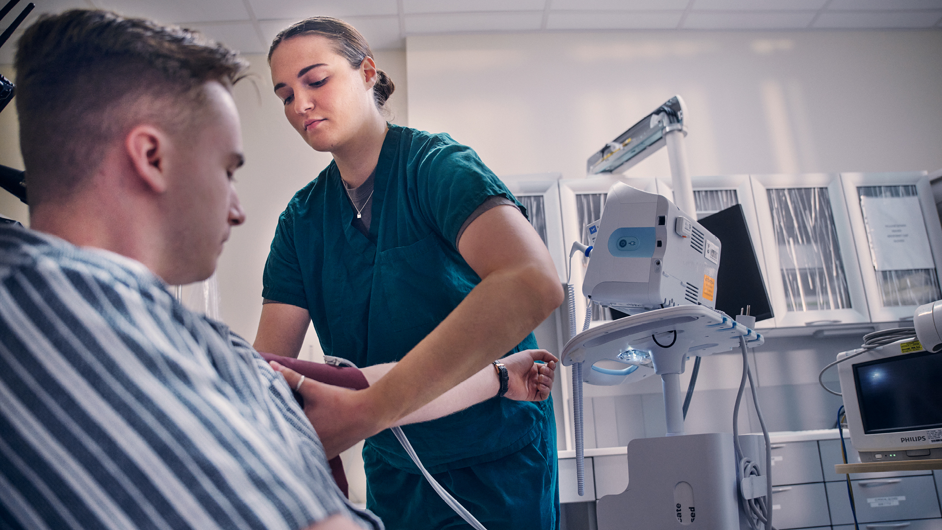 Francesca Lograsso measuring someones blood pressure in a dental exam room