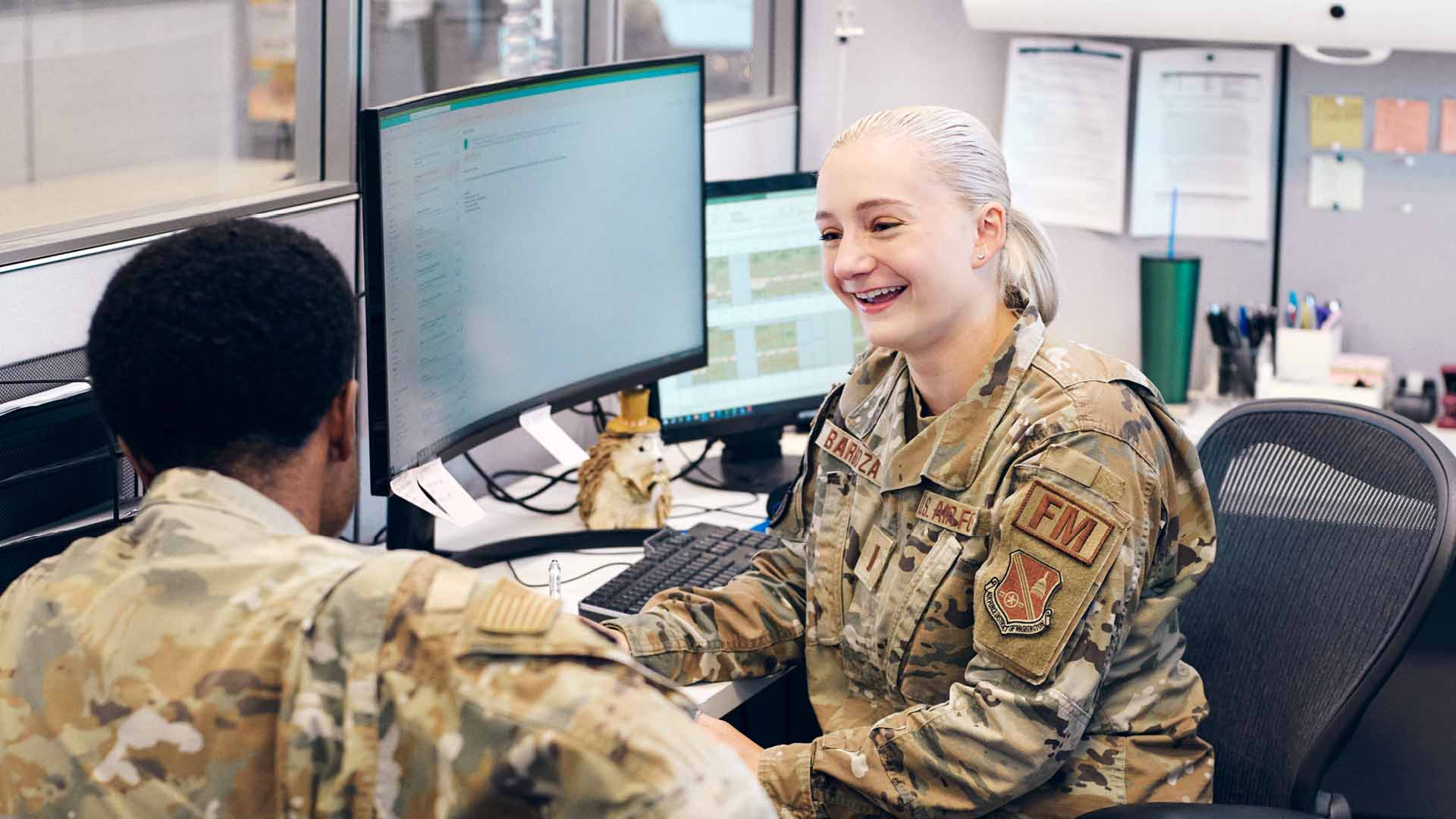 Hope Barboza laughing with another service member at her desk