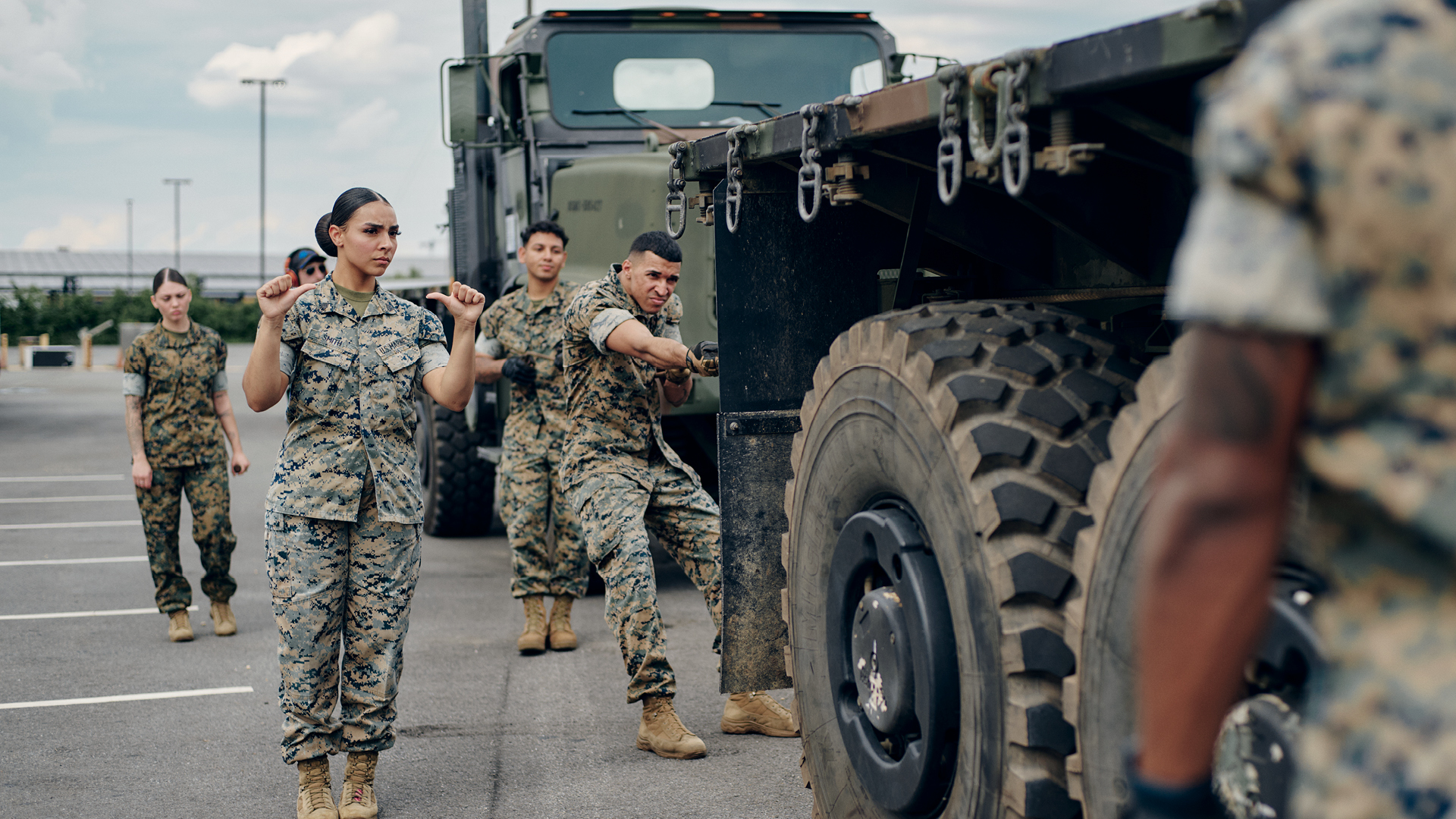 Kendyl Smith and other service members setting up a winch between tactical trucks.