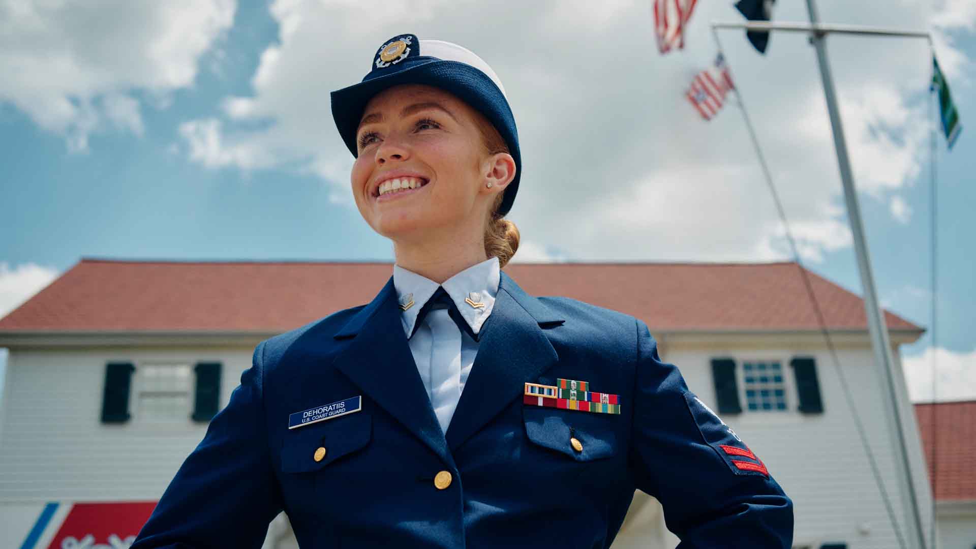 Taylor DeHoratiis standing in front of a Coast Guard station building