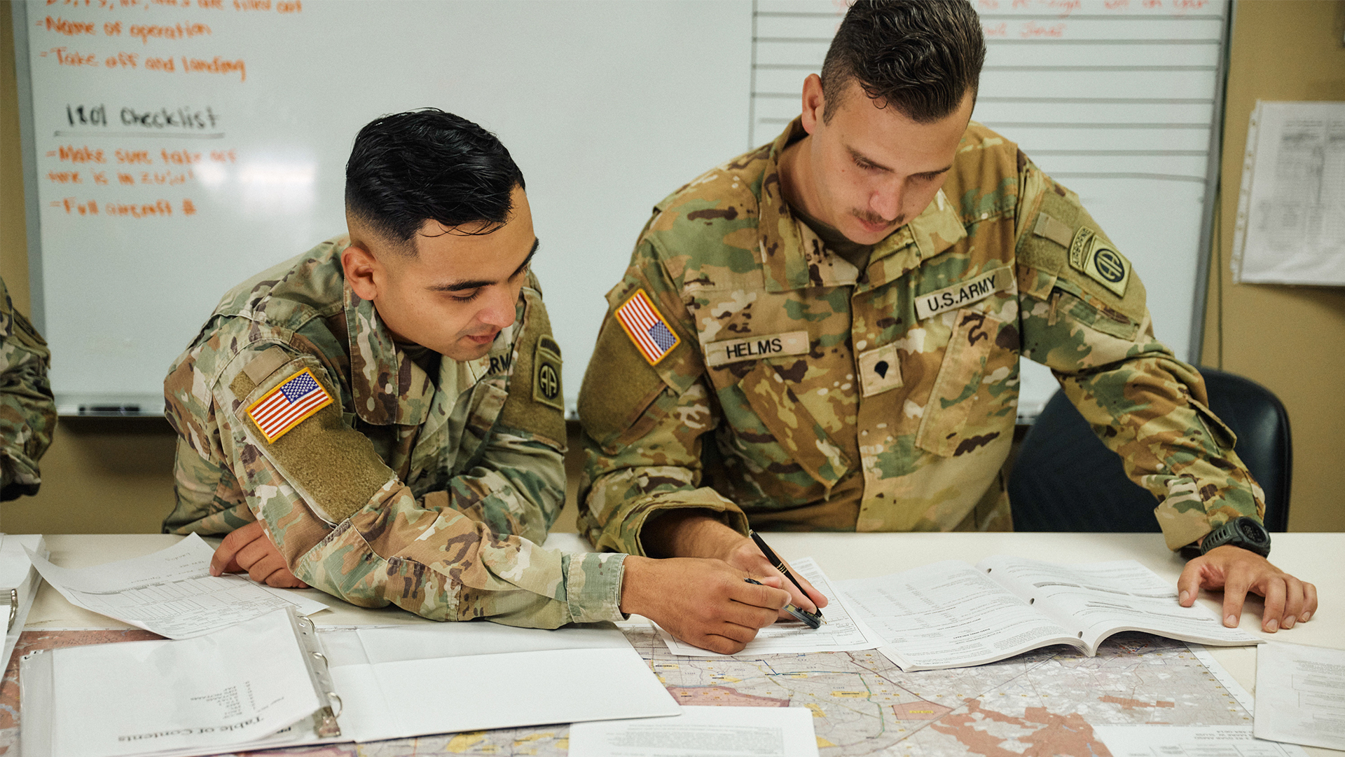 Luis Villegas working with another service member looking at a map